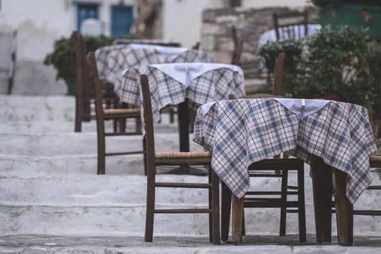 Tavolini di una taverna sui gradini di un vicolo greco
