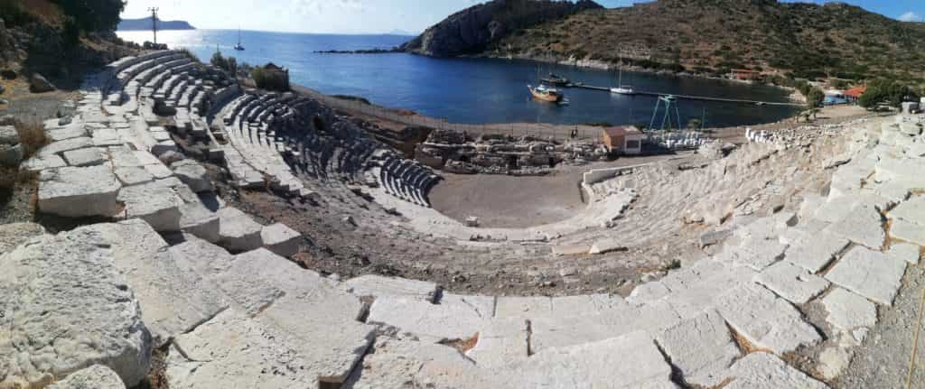 Un teatro antico affacciato su una baia con i caicchi all'ormeggio
