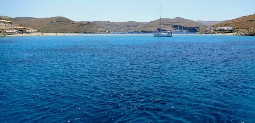 Barca a vela all'ancora davanti alla spiaggia in una grande baia riparata